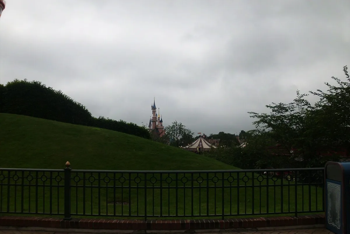Het kasteel van Doornroosje in Disneyland Parijs achter een groene heuvel
