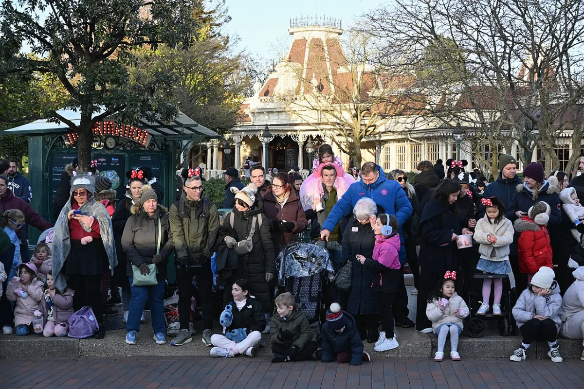 Gezinnen met jonge kinderen en een kinderwagen wachten in Disneyland Parijs