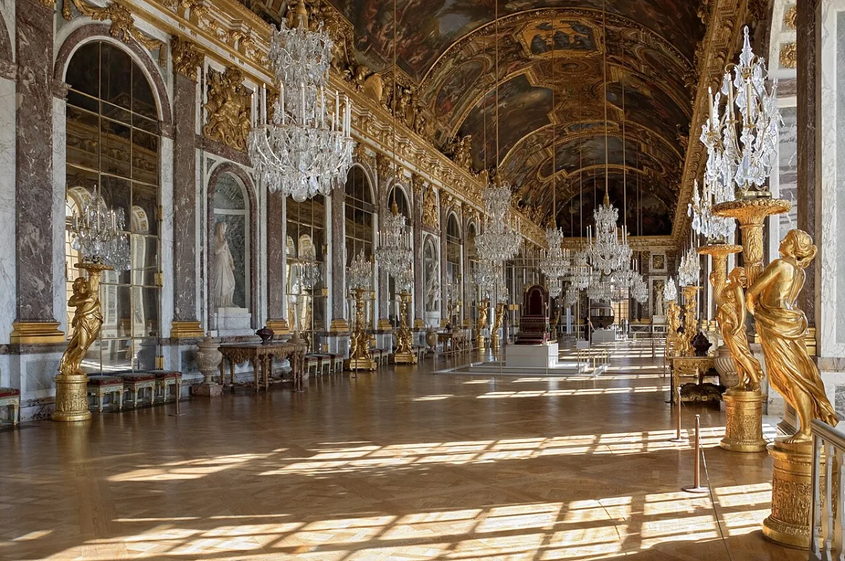 De Spiegelzaal van het paleis van Versailles met kroonluchters en gouden beelden