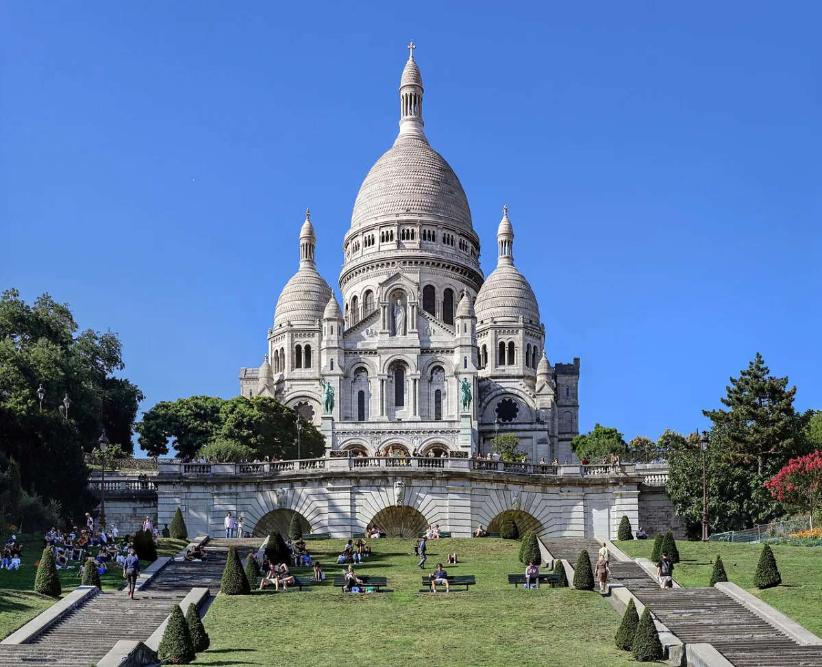 De Sacré-Cœur basiliek op Montmartre met bezoekers op het grasveld ervoor