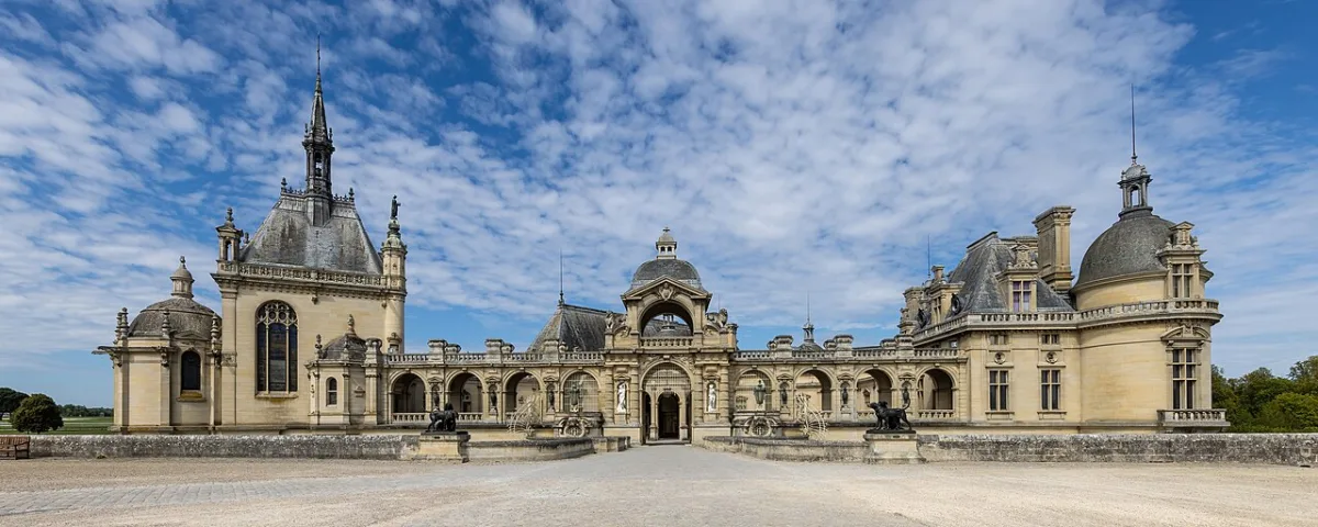 Voorgevel van het Château de Chantilly onder een blauwe lucht
